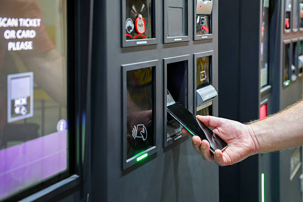 istock Smart payment at a modern self-service terminal: a customer taps a smartphone on the illuminated reader to complete a digital transaction. Sleek design highlights the ease of contactless tech. 2247632526