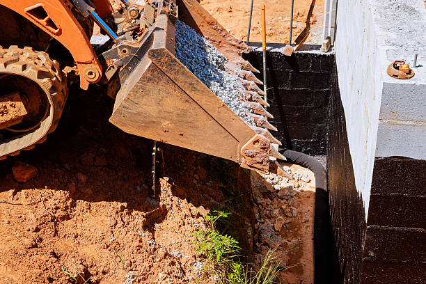 istock Excavator working on construction site with gravel near building foundation 2247633313