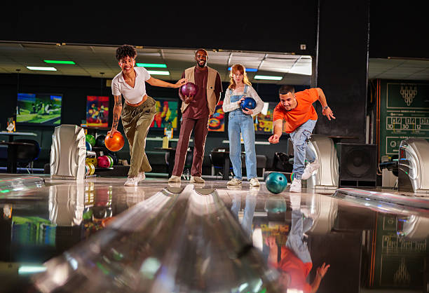 istock Group of young adults enjoying a lively bowling night, laughing and competing while throwing balls and aiming for strikes together 2247633986