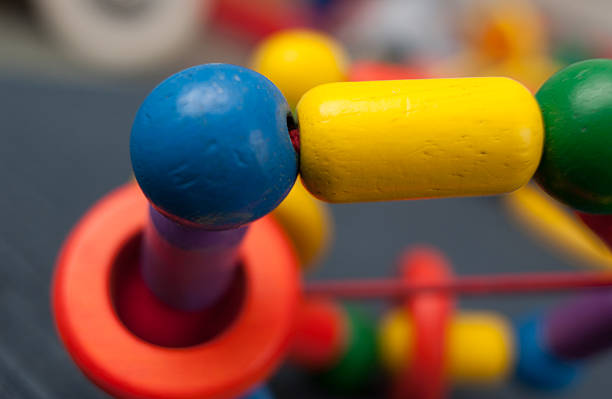 Close up of wooden multicolor bead toy connected by strings.