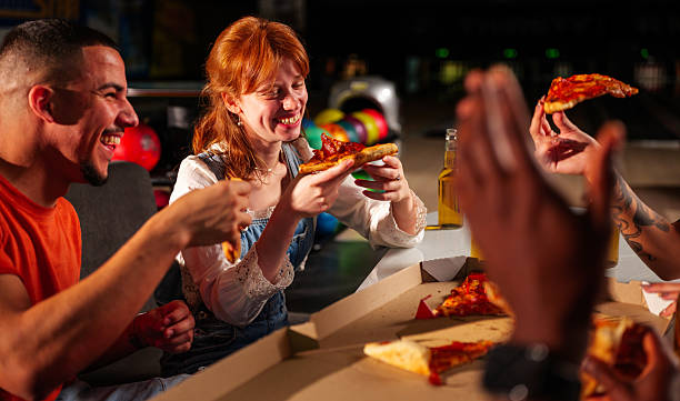 istock Cheerful friends enjoying pizza and drinks, sharing laughter and creating lasting memories while having fun at the bowling alley 2247635589