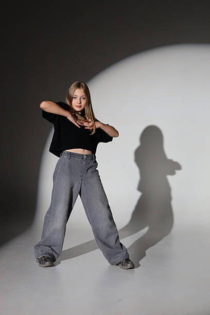 Young caucasian female posing in studio with shadow on wall