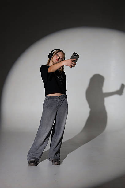 istock Young asian female with headphones taking selfie in studio 2247635679