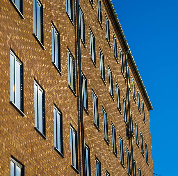 istock Angled view of brick residential building with bright blue sky.. 2247635703