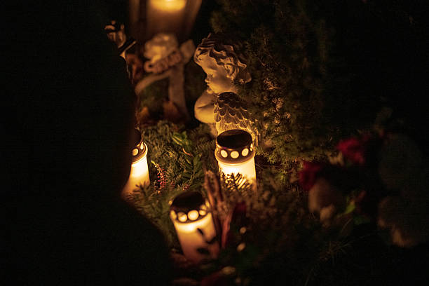 istock Memorial candles glowing warmly in darkness at night cemetery.. 2247635791