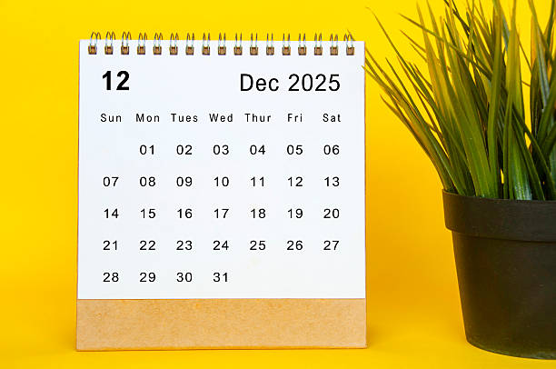 istock White December 2025 calendar on yellow cover background. Year end concept. 2247638548