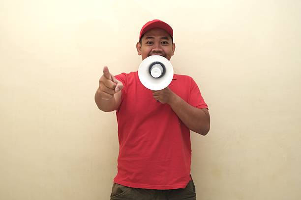 istock Southeast Asian man with megaphone pointing forward for ad 2247639386