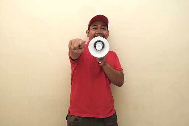istock Southeast Asian man with megaphone pointing forward for ad 2247639391