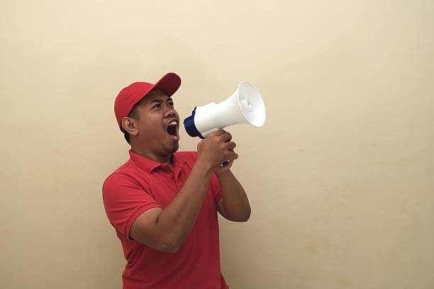 istock Southeast Asian man shouting into megaphone isolated for ad 2247639395