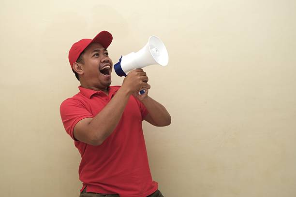 istock Southeast Asian man shouting into megaphone isolated for ad 2247639400