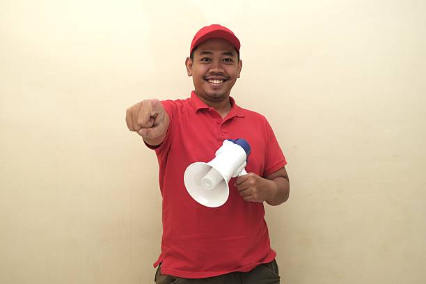 istock Southeast Asian man with megaphone pointing forward for ad 2247639409