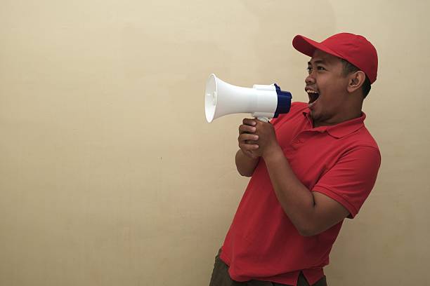 istock Southeast Asian man shouting into megaphone isolated for ad 2247639434