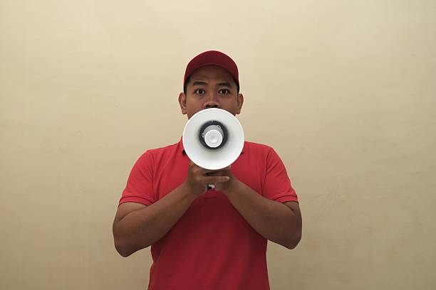 istock Southeast Asian man shouting into megaphone isolated for ad 2247639463