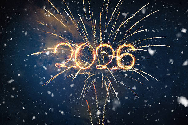 istock Bright 2026 text written with golden sparks or light trails, superimposed over a stunning fireworks display in a dark, snowy winter night sky. New Year celebration concept. 2247642577