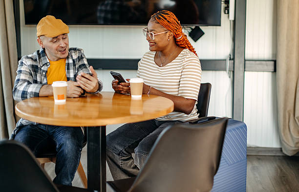 istock Multiracial couple waiting for transportation at cafe going on vacation with suitcases and having a talk 2247642694