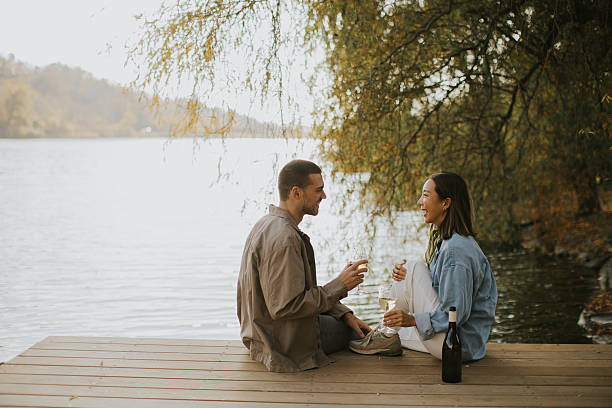 istock Joyful moments by the lake, sharing laughter and drinks during a sunny afternoon 2247643916