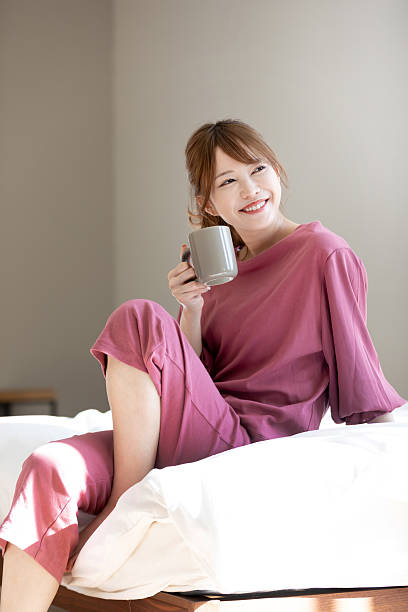 Asian woman drinking coffee to wake up