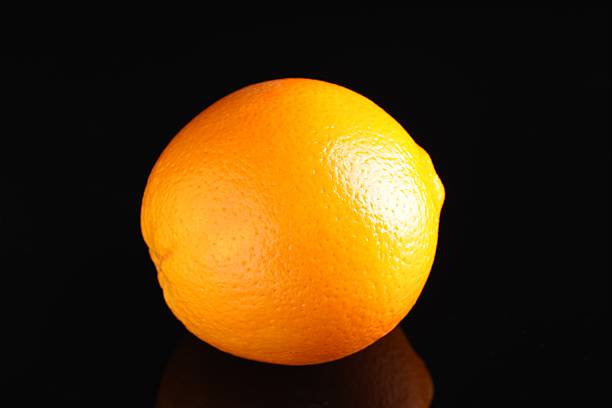 istock One fresh orange on black mirror surface, closeup 2247648126