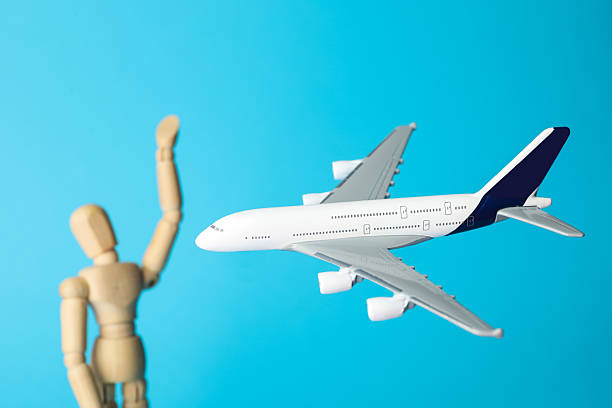 istock Plane model and wooden human figure on light blue background, closeup 2247648316