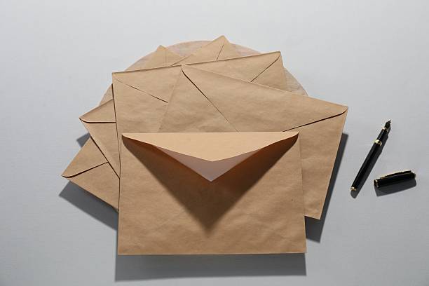 istock Kraft paper envelopes and fountain pen on grey background, flat lay. Mockup for design 2247648996