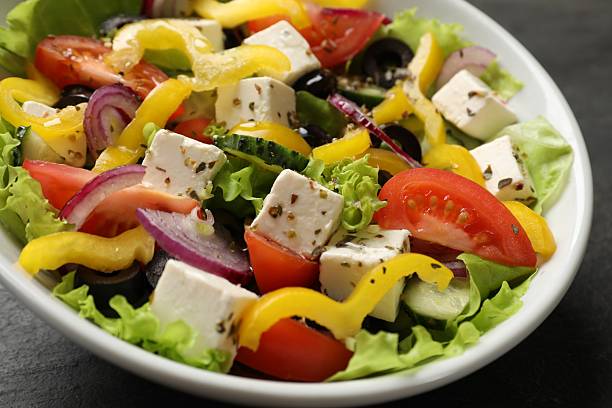 istock Delicious fresh Greek salad in bowl on table, closeup 2247649544