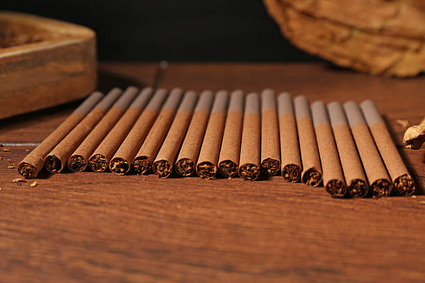 istock Cigarettes with tobacco on wooden table, closeup 2247649675