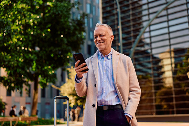 istock Mature man smiling using smartphone during business travel 2247649794