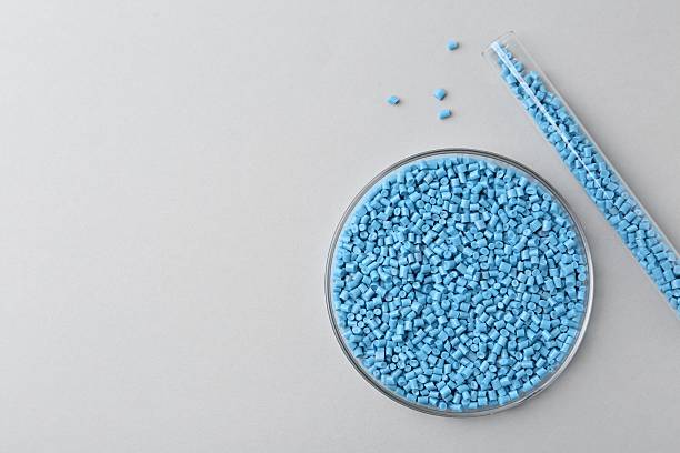 istock Light blue plastic granules in petri dish and test tube on gray background, flat lay. Space for text 2247649905