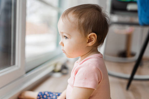 istock cute and Adorable girl look through window outside 2247652765