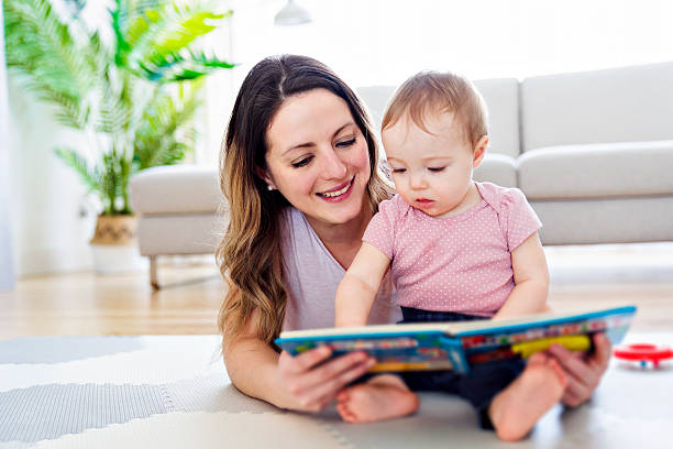 istock a happy mother with baby reading book 2247653111