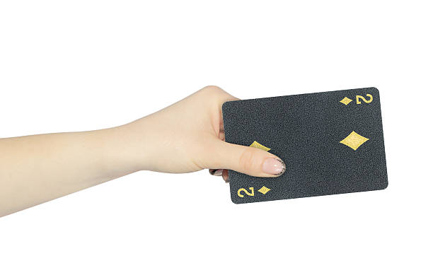 istock playing card diamonds 2 in hand, outstretched hand with black playing card isolated from background 2247653466
