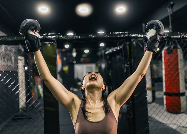 istock female fighter  celebrating victory in the ring 2247655172
