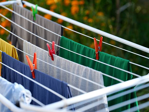 Washed laundry hanging on a clothing dryer rack outdoors