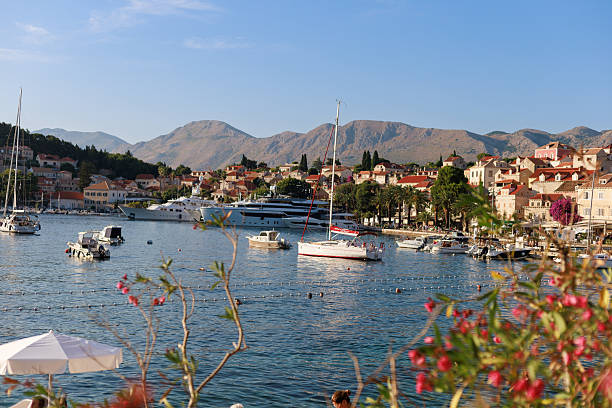 Cavtat, Croatia — 2 July 2025: Cavtat waterfront with boats, hills, and old town houses under soft light. Concept of coastal travel, scenic poster design, tourism promotion, and Mediterranean atmosphere.
