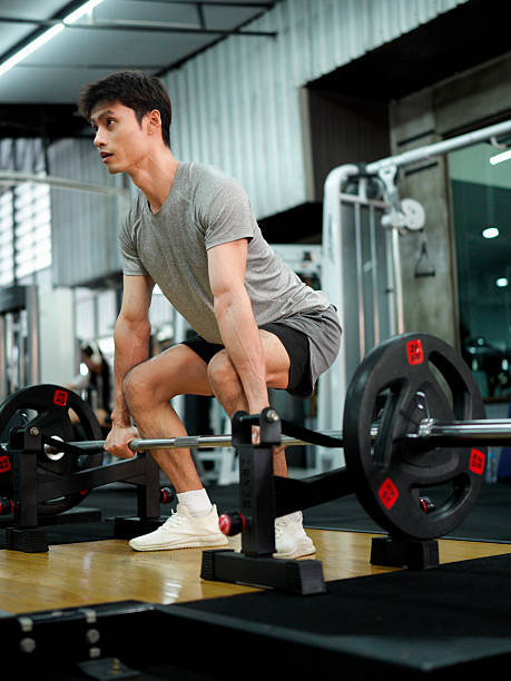 istock muscular body builder sport man is practice weight training on squat barbell for core muscle inside gym with dark background for exercising and workout usage 2247657683