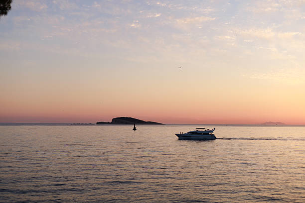 Simple seascape with soft pastel sunset colors and a small distant boat. Great for minimalistic designs, calming prints and modern graphic layouts.