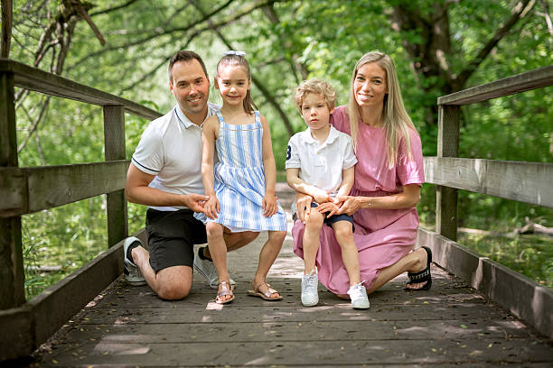 istock Father and mother with the son and daughters having fun outside in forest 2247658578