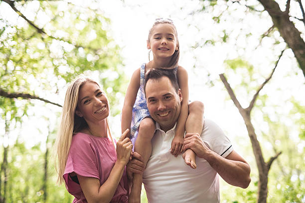istock Father, mother with his daughter having fun outside in forest 2247658586