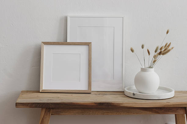 istock Minimalist home decor scene. Two blank picture frames. Wooden bench, table, white ceramic vase with dried lagurus flowers. Modern neutral interior mockups for artwork, prints, posters. Branding. 2247658599