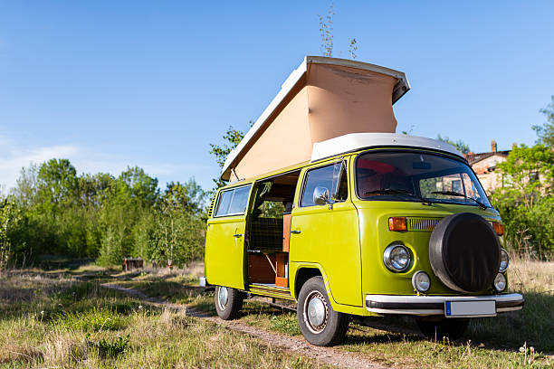 Germany - May 16, 2020: An old green Volkswagen VW Bus T2 stands on a meadow in the countryside. The special feature of this model is the pop-up roof, which provides extra comfort.