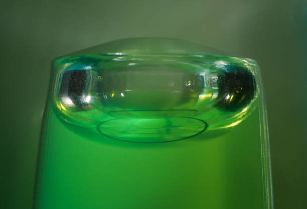 A construction-level flask with green liquid and an air bubble in close-up