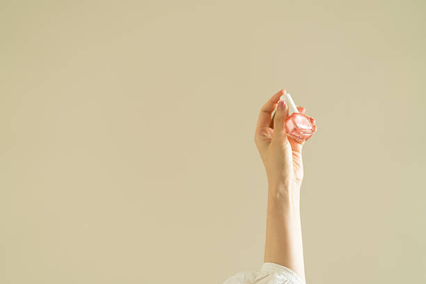 istock woman's hand holding pink nail polish. 2247659720