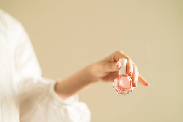 istock woman's hand holding pink nail polish. 2247660017