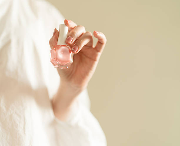 istock woman's hand holding pink nail polish. 2247660074
