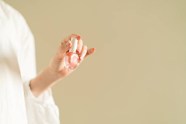 istock woman's hand holding pink nail polish. 2247660365