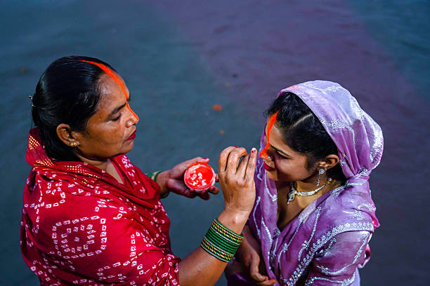 Hindu devotees apply tika after performing rituals and offer prayers to the setting Sun God during the Chhath Puja festival in Kathmandu, Nepal, on October 27, 2025.