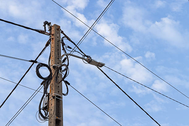 istock A concrete utility pole featuring a modern LED streetlight and coiled black cables. 2247665517