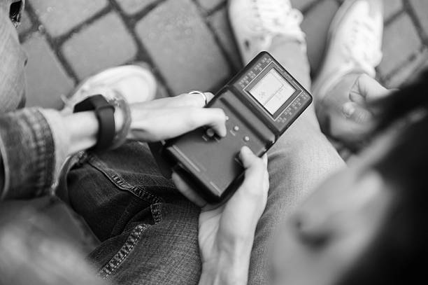 istock Young people engaged with a handheld device outdoors in a park setting.Technologies of the 90s. 2247665959
