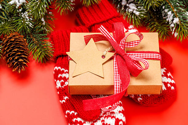 istock Gift box on winter mittens and red background 2247668784