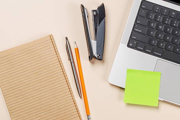 istock Blank notepad, laptop and stationery on beige workspace, top view with copy space 2247669154